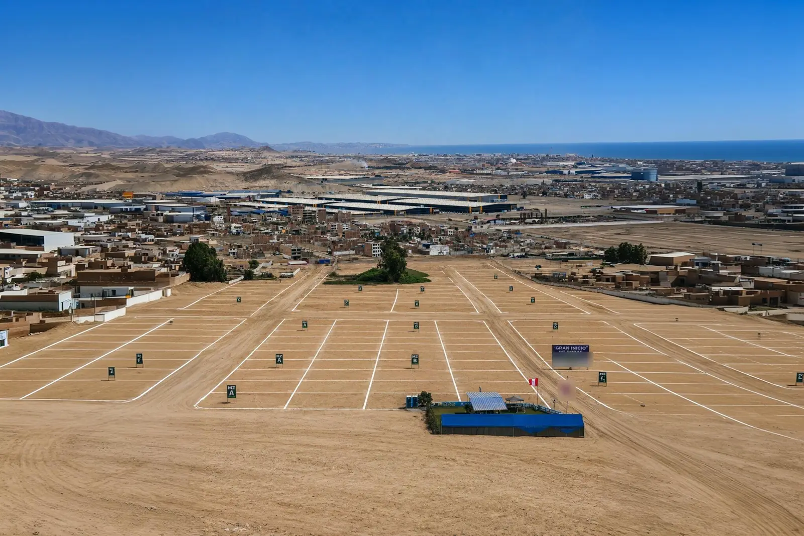 Vista aérea del terreno lotizado en Lurín, con manzanas y calles trazadas y el mar al fondo